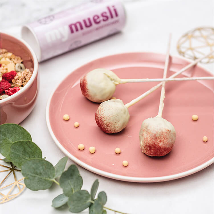 Müsli-Cake-Pops auf einem Teller mit Spießen