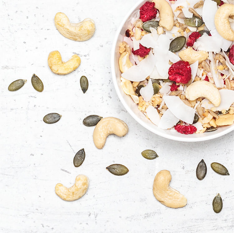 Eine Schale mit Nüssen, Himbeeren und Kernen