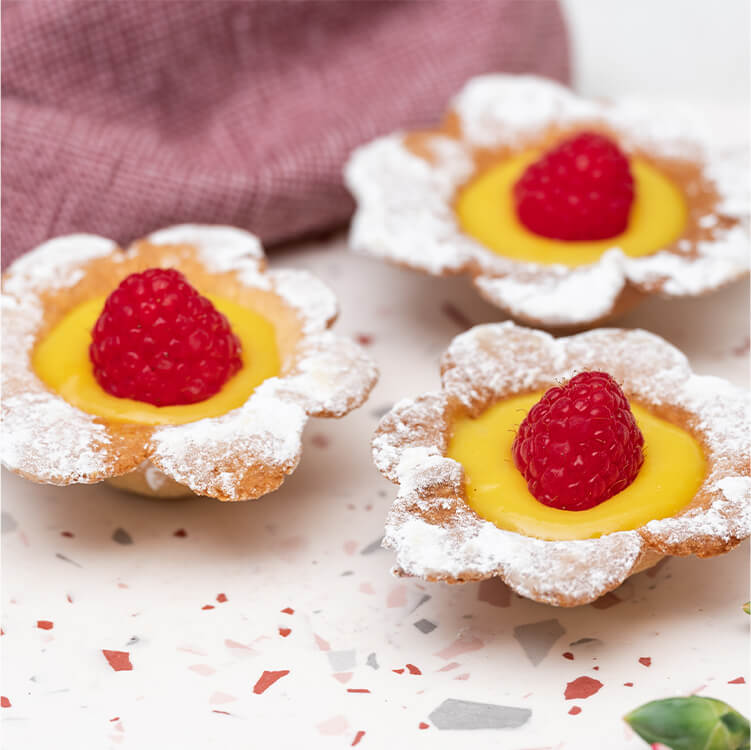 Himbeer-Lemon Curd Blumen Tartes auf dem Tisch