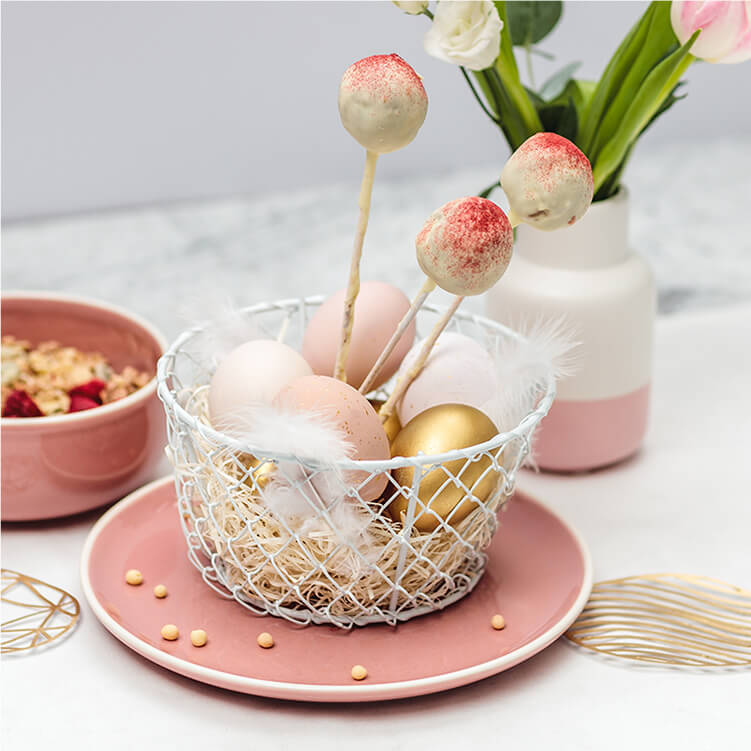 Müsli-Cake-Pops mit Spießen in einer Schale mit Ostereiern