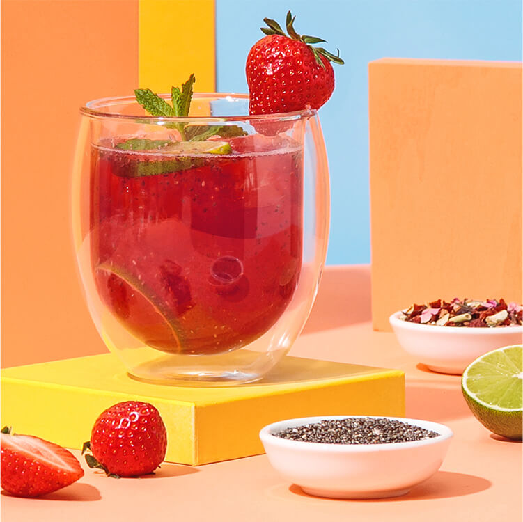 Erdbeer Chia Eistee im Glas mit einer Schüssel Chia Samen