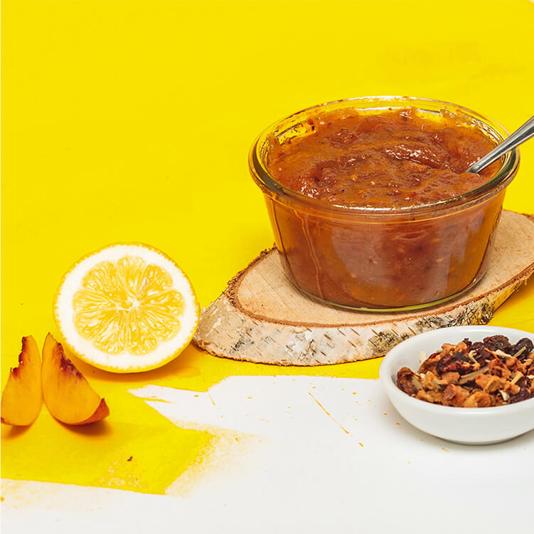 Vanille Pfirsichmarmelade im Glas mit Löffel und einer halben Zitrone
