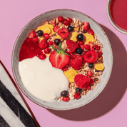 mymuesli Bio Berry Müsli mit Himbeeren, Erdbeeren und Blaubeeren in Schüssel mit frischen Beeren und Joghurt