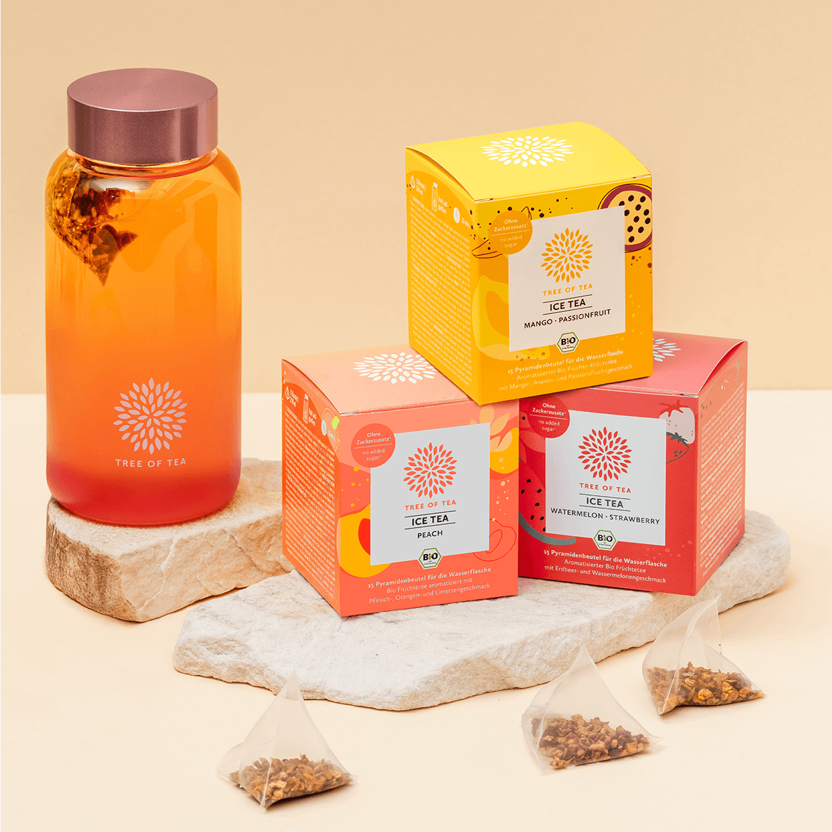 Tree of Tea Ice Tea Starter Set mit Mango Passionfruit, Peach, Watermelon Strawberry und rosa Ice Tea Bottle auf einer Steinplatte vor minimalistischem Hintergrund.