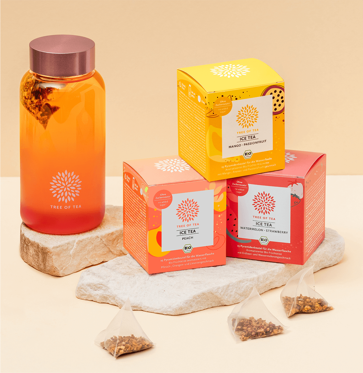 Tree of Tea Ice Tea Starter Set mit Mango Passionfruit, Peach, Watermelon Strawberry und rosa Ice Tea Bottle auf einer Steinplatte vor minimalistischem Hintergrund.