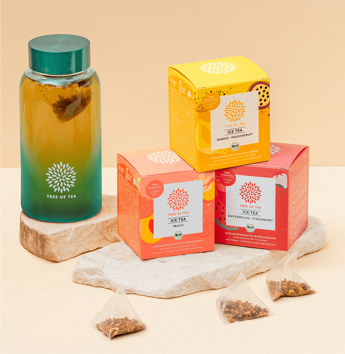 Tree of Tea Ice Tea Starter Set mit Mango Passionfruit, Peach, Watermelon Strawberry und türkiser Ice Tea Bottle auf einer Steinplatte vor minimalistischem Hintergrund.