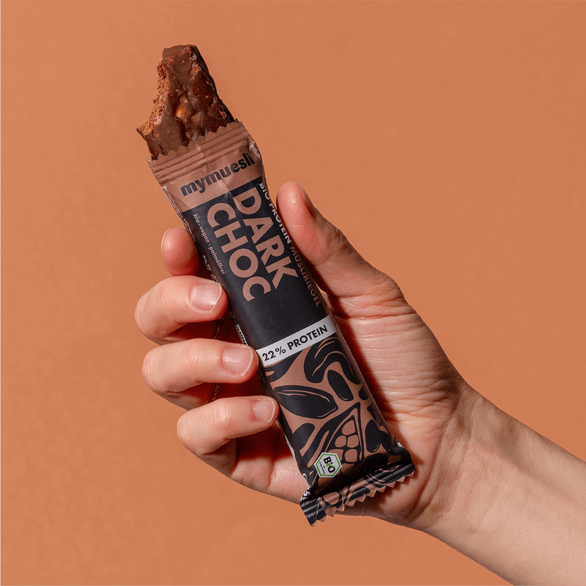 mymuesli Bio Protein Müsliriegel Dark Choc ausgepackt mit abgebissener Ecke.
