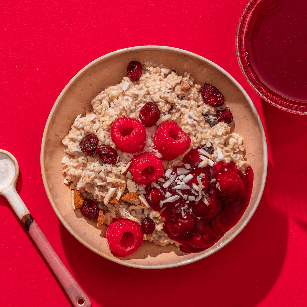 mymuesli Bio Raspberry Coconut Porridge in Schale mit frischen Beeren und Nüssen
