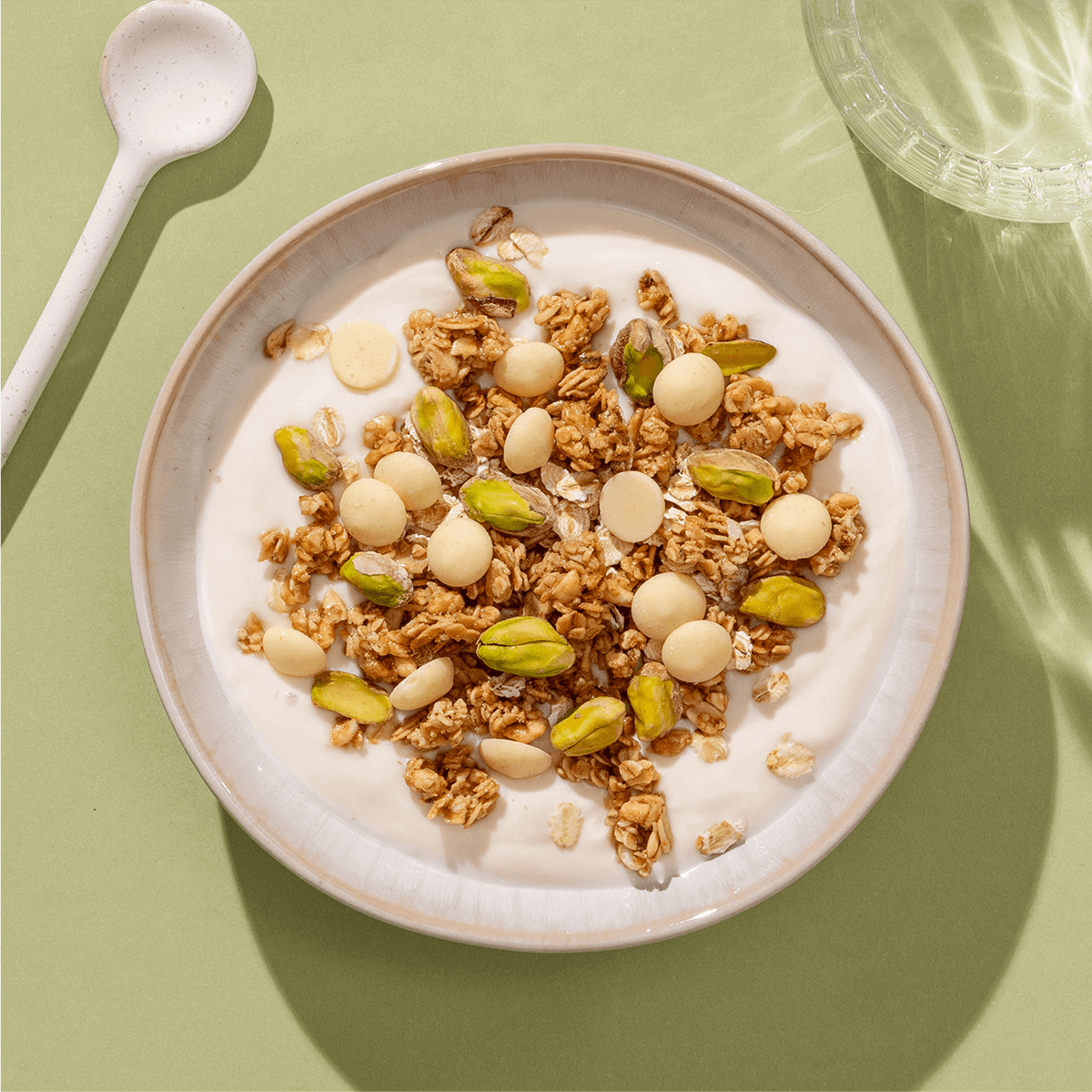mymuesli Bio White choc pistachio Crunch in Schale mit frischen Pistazien