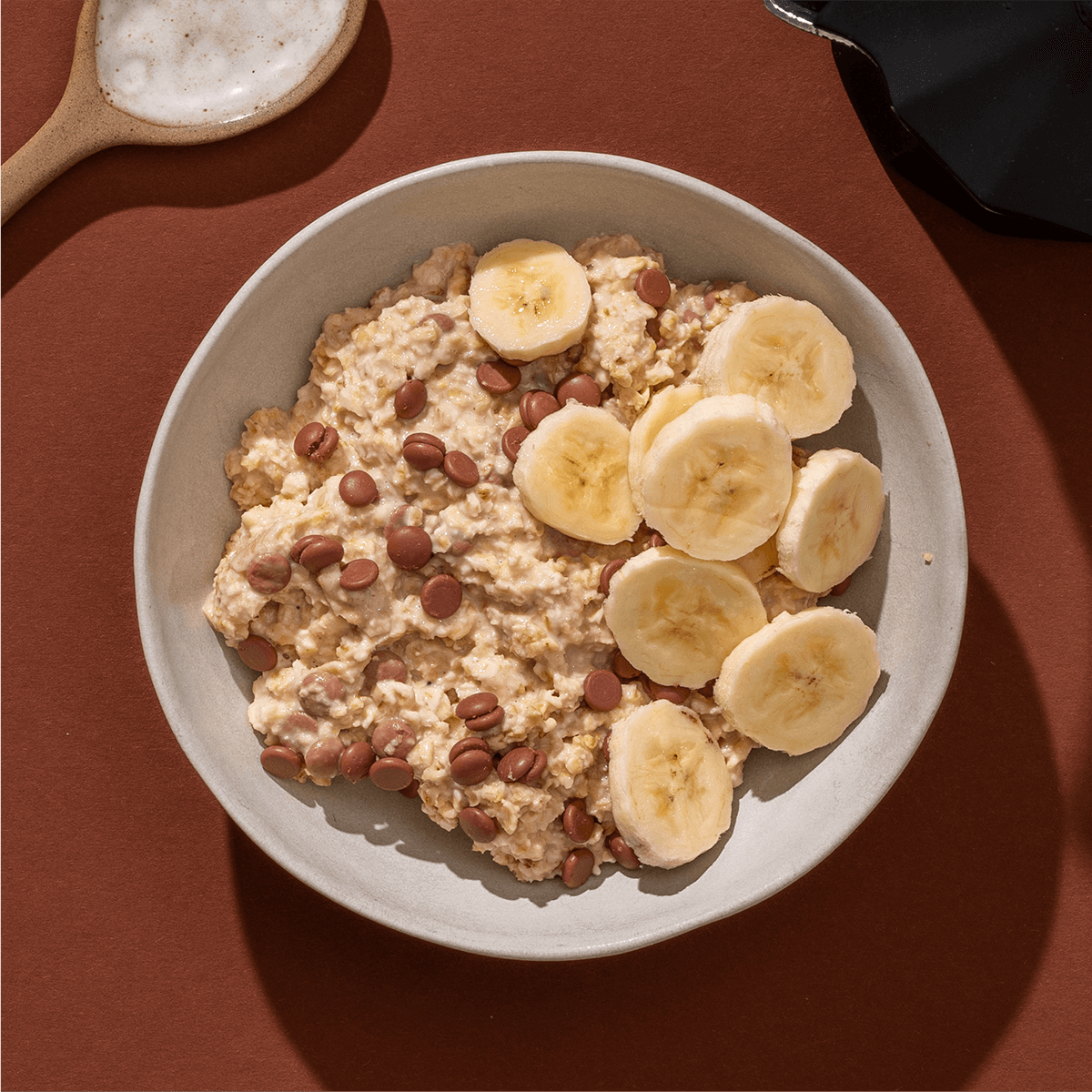 mymuesli Bio Banana Choc Porridge in Schale mit frischen Bananen
