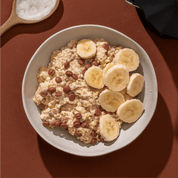 mymuesli Bio Banana Choc Porridge in Schale mit frischen Bananen