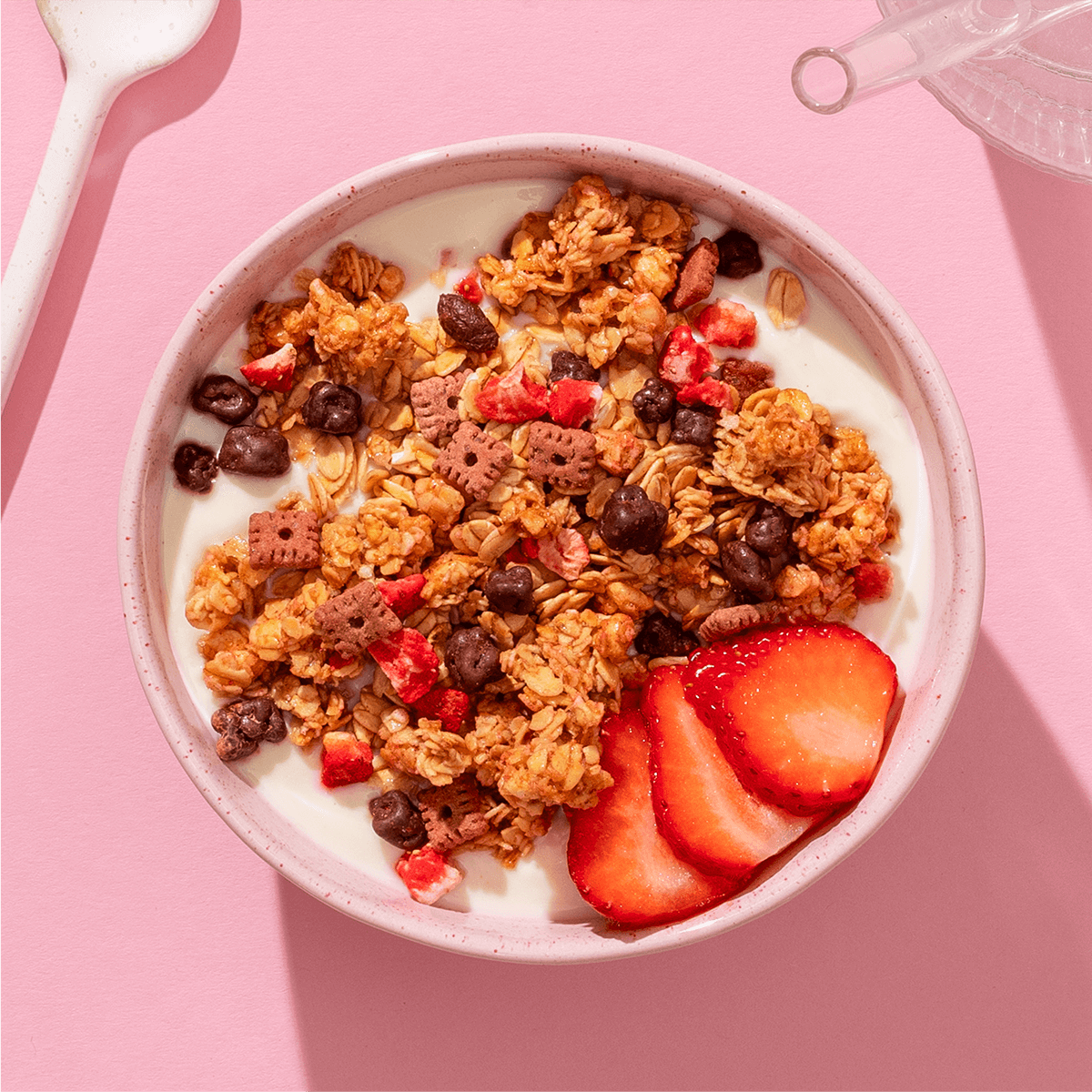 mymuesli Bio Strawberry Choco Crunchy Granola in Schale mit Joghurt und frischen Erdbeeren
