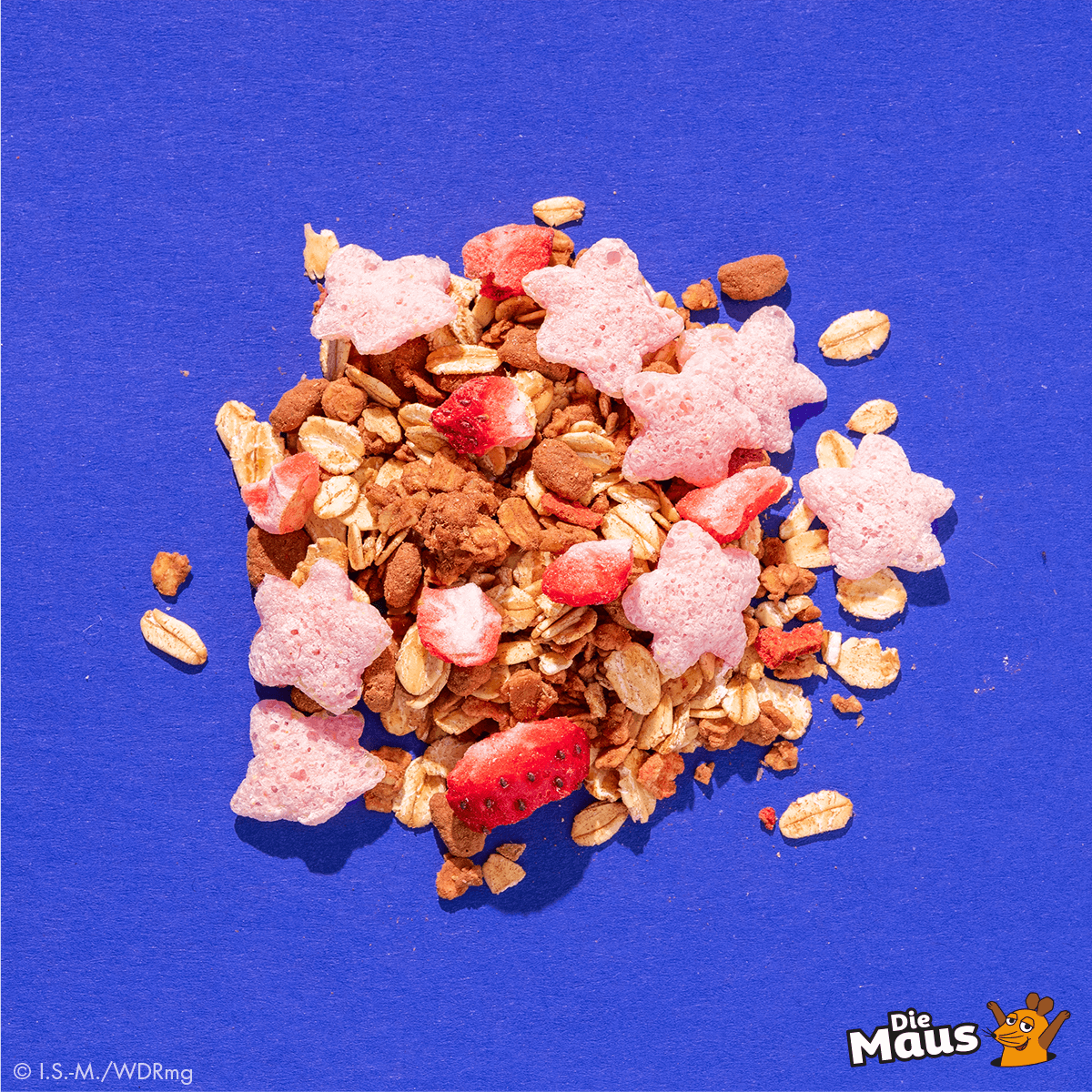 Mymuesli bio Superelefanten-Müsli Zutaten von oben mit Erdbeeren und pinken Sternen.