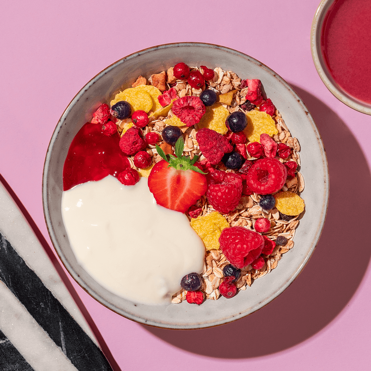mymuesli Bio Berry Müsli in Schale mit Joghurt und Beeren-Kompott