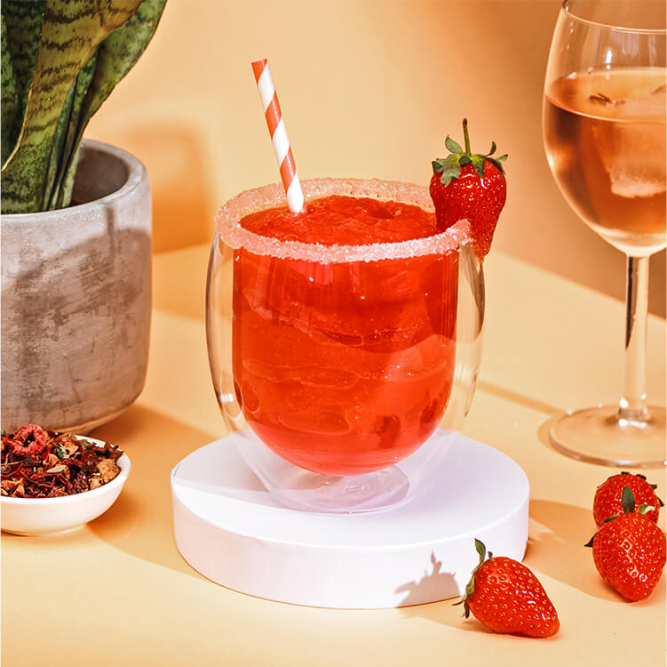 Erdbeer Frosé im Glas mit Erdbeeren daneben