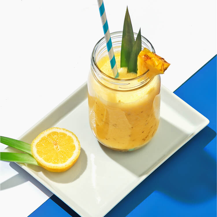 Ananas Passionsfrucht Smoothie mit einer halben Zitrone
