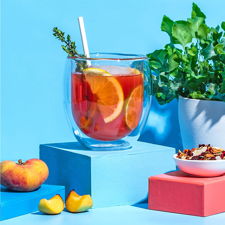 Peachy Ginger Lemonade mit Limettenscheiben und Thymian dekoriert