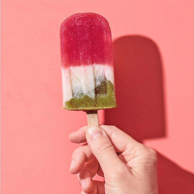 Ein Popsicle-Eis mit Wassermelone in einer Hand