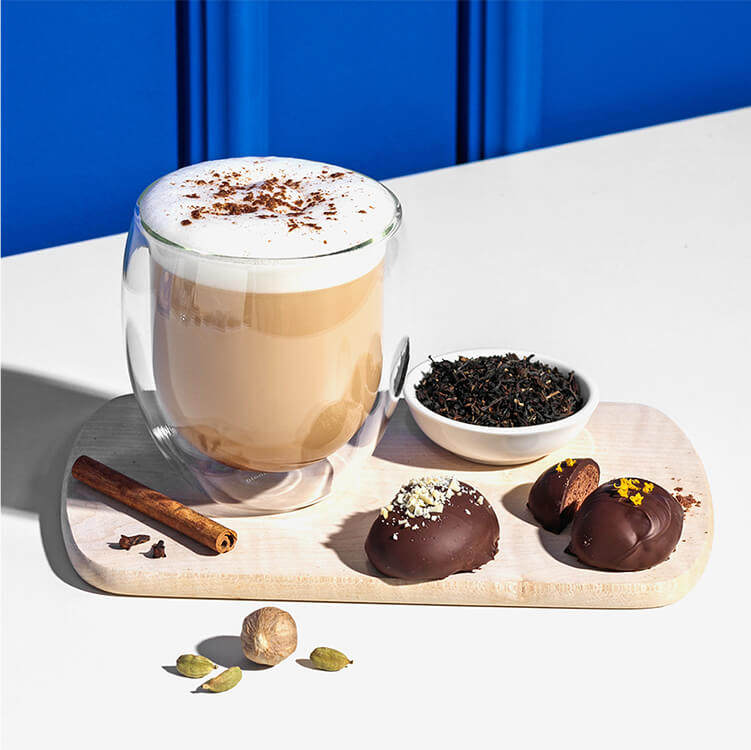 Lebkuchen Chai Latte mit Gewürzen und Tee daneben