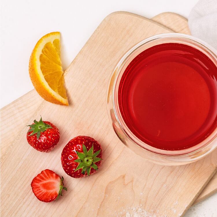 Tee auf einem Brett mit Erdbeeren daneben