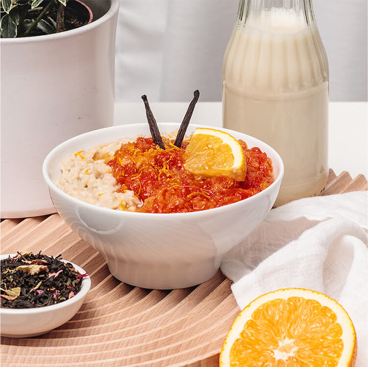 Miss Grey Porridge mit einer halben Orange und einer Schüssel Tee daneben