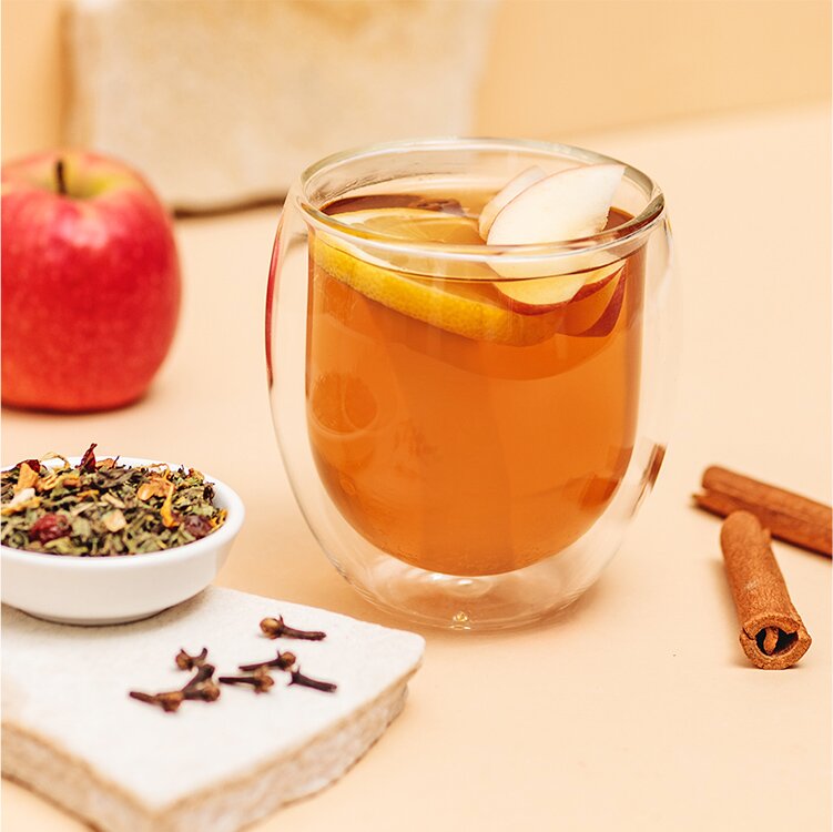 Apfel Kräuter Punsch mit Apfel, Zimstangen und Tee daneben