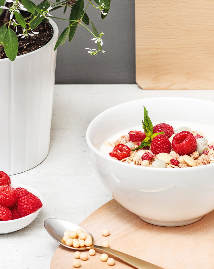 article4b-muesli-berry-white-choc.jpg Mueslischale mit weisser Schokolade und Himbeeren als Topping