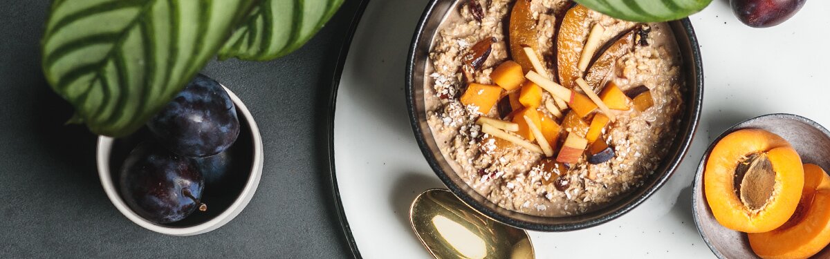 Bio-Porridge im 45g Portionsbecher mit Pflaumenstücken und Zimt.