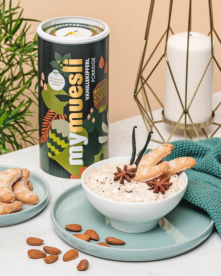 mymuesli Vanillekipferl Porridge dekoriert mit Sternanis, Vanille, Mandeln und Gebaeck