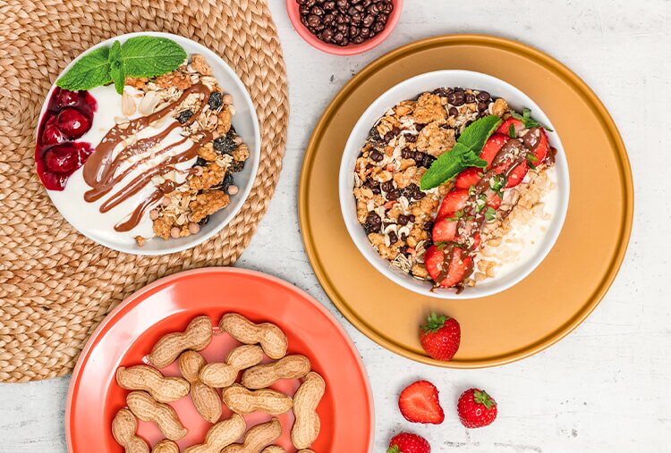 Granola mit Erdbeeren und Granola mit Kirschen in Schuesseln