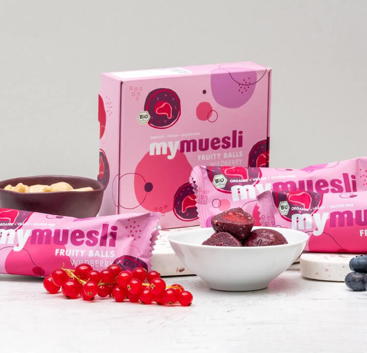 Neun Fruity Balls mit Datteln Cashew und Beeren in einer stylischen rosa Box