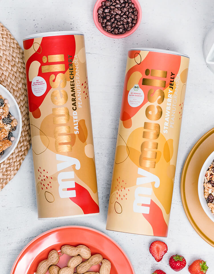 article4b-muesli-peanut-granola-deluxe.jpg mymuesli Penaut Granola Dosen und Granola und Zutaten in Schuesseln