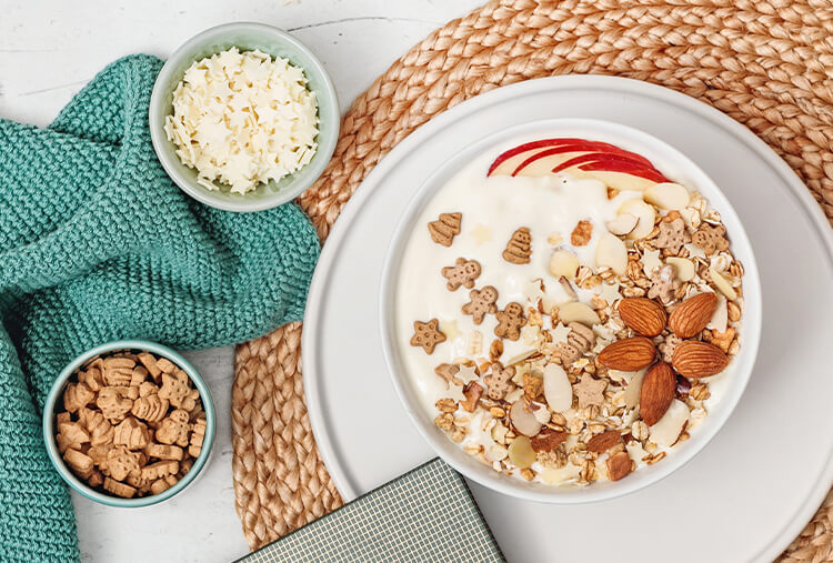 Granola mit kleinen Spekulatiuskeksen und Mandeln in der Schuessel